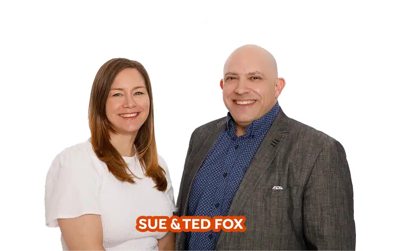 A woman in a white top and a man in a gray blazer stand side by side, smiling at the camera. Text at the bottom reads "Sue & Ted Fox—proud to call Kamloops home.